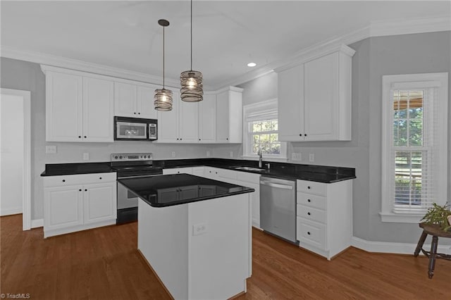 kitchen with dark hardwood / wood-style floors, a kitchen island, white cabinetry, and stainless steel appliances