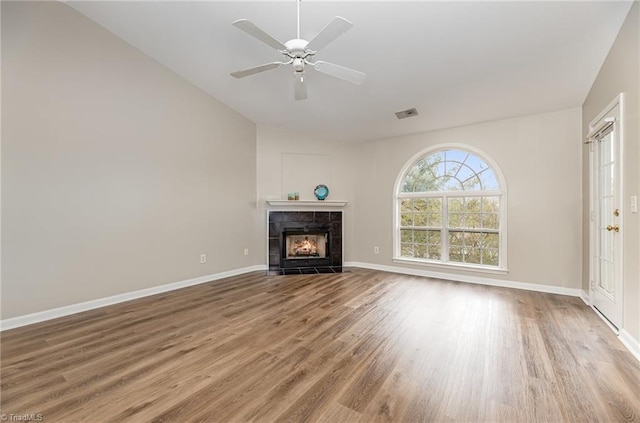 unfurnished living room with wood finished floors, a fireplace, visible vents, and baseboards