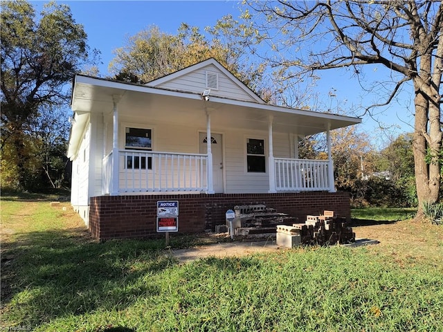 bungalow-style home with a front lawn and covered porch