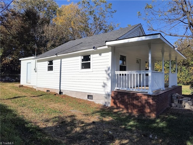 view of side of home with a lawn and a porch