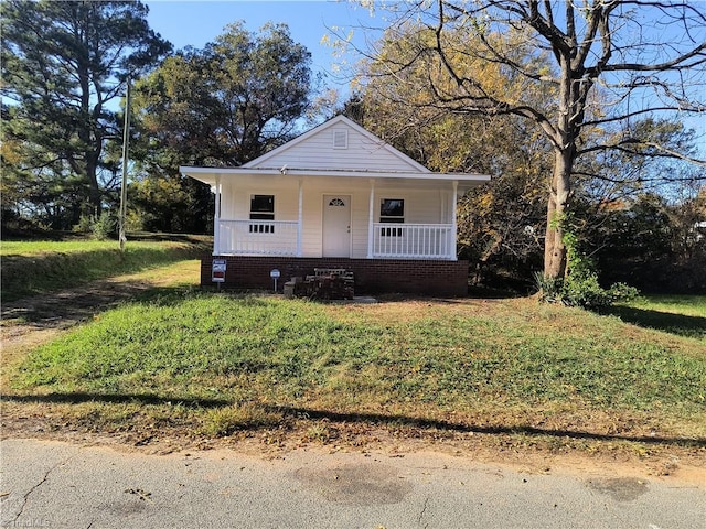 bungalow-style house featuring covered porch and a front lawn