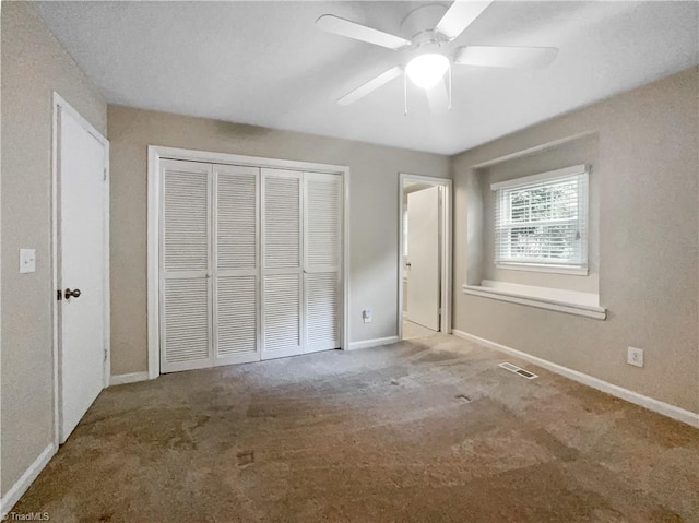 unfurnished bedroom with ceiling fan, carpet floors, and a closet