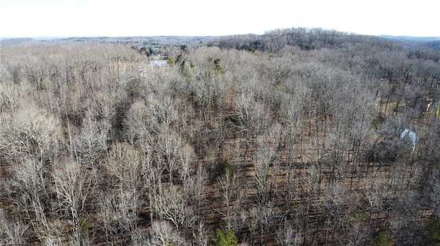 drone / aerial view with a wooded view