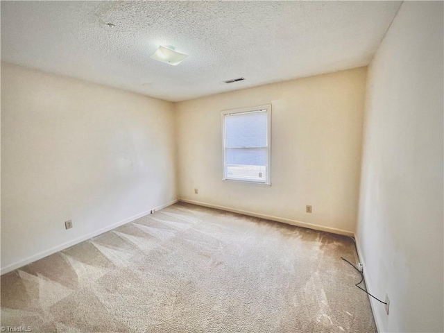 empty room featuring baseboards, a textured ceiling, visible vents, and carpet flooring