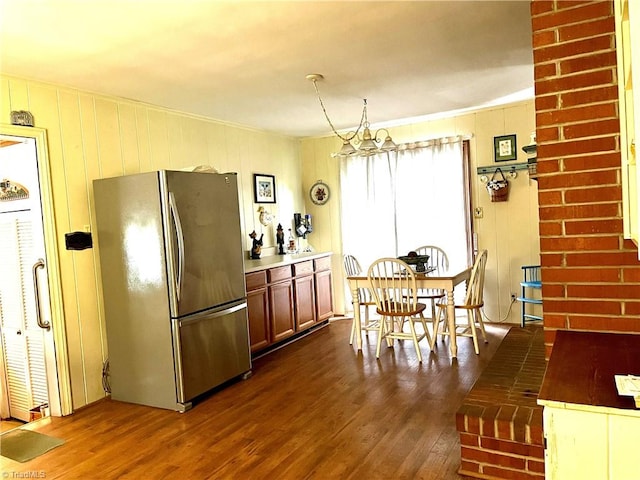 kitchen featuring an inviting chandelier, stainless steel fridge, dark hardwood / wood-style floors, and decorative light fixtures