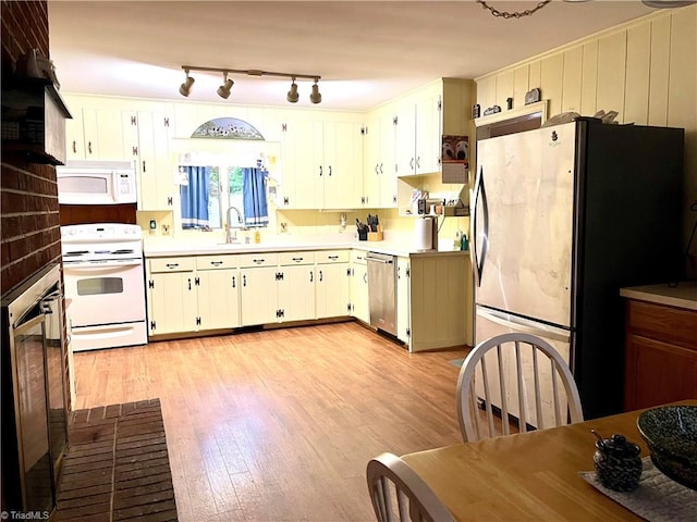 kitchen featuring light hardwood / wood-style flooring, white cabinets, white appliances, and sink