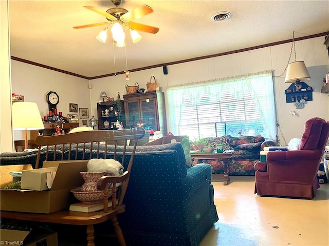 living room featuring a textured ceiling, concrete floors, ornamental molding, and ceiling fan