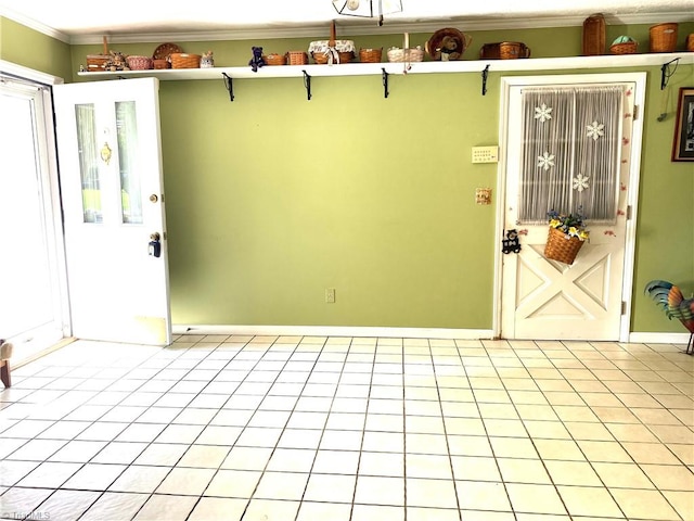 foyer entrance with ornamental molding and light tile patterned floors