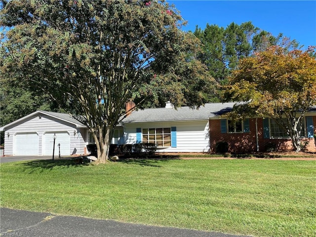 view of front of property featuring a front lawn, an outdoor structure, and a garage