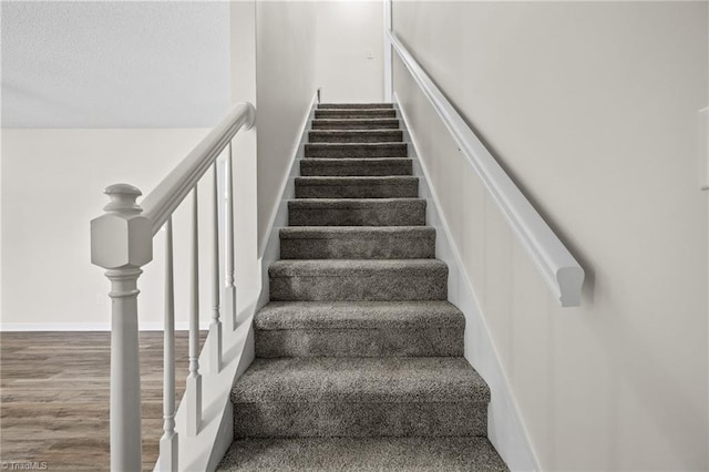 stairs featuring hardwood / wood-style floors