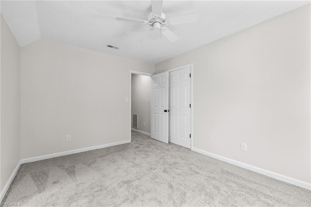 carpeted empty room featuring ceiling fan and lofted ceiling