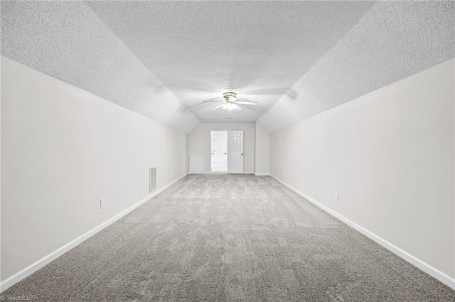 bonus room with carpet flooring, a textured ceiling, vaulted ceiling, and ceiling fan