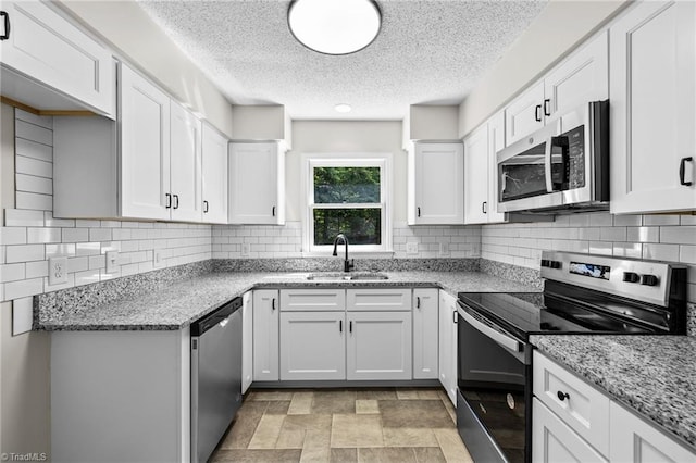 kitchen featuring white cabinetry, sink, light stone countertops, and appliances with stainless steel finishes