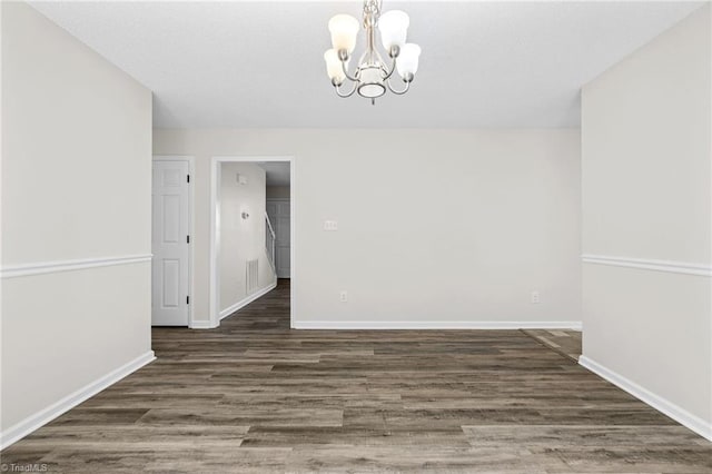 unfurnished dining area featuring a notable chandelier and dark hardwood / wood-style floors