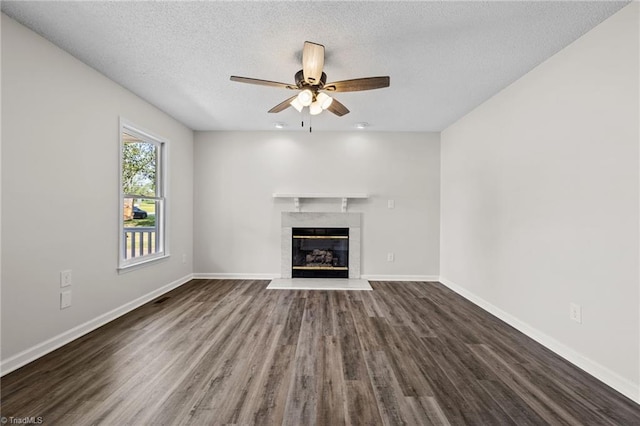 unfurnished living room with a textured ceiling, dark hardwood / wood-style floors, ceiling fan, and a premium fireplace