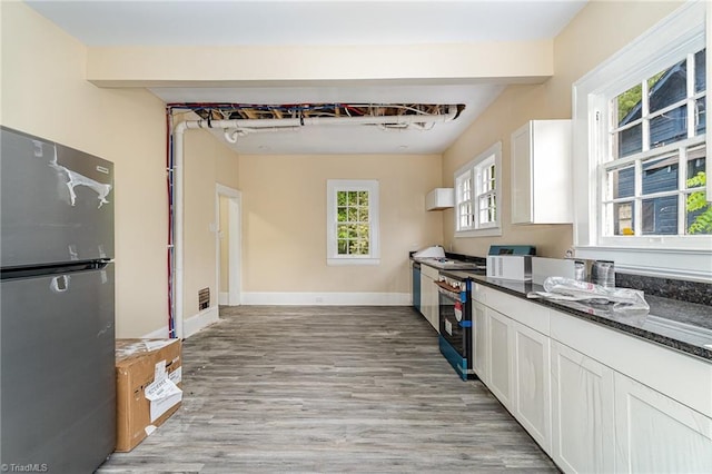 2515 N Patterson Ave, Winston-Salem, NC 27105 - kitchen with freestanding refrigerator, light wood-style flooring, white cabinetry, and dark stone counters