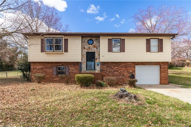 split foyer home with brick siding, concrete driveway, a garage, stone siding, and a front lawn