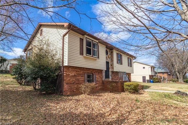 view of side of home featuring a yard and brick siding