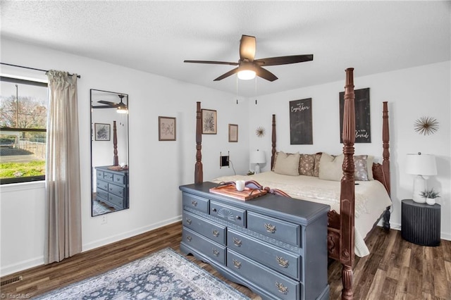 bedroom with visible vents, dark wood-type flooring, ceiling fan, a textured ceiling, and baseboards