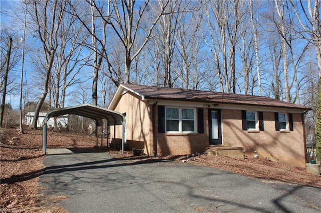 view of front of home with aphalt driveway, brick siding, and a carport