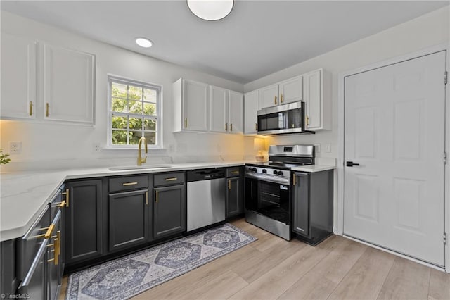 4908 Peppercorn Ln, Greensboro, NC 27406 - kitchen with appliances with stainless steel finishes, white cabinetry, and light wood-style floors