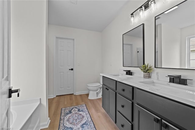 4908 Peppercorn Ln, Greensboro, NC 27406 - bathroom featuring double vanity, wood finished floors, and a tub