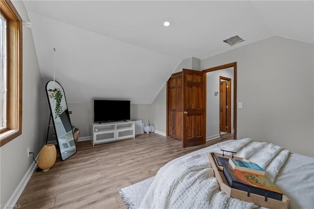 bedroom featuring light hardwood / wood-style floors and lofted ceiling