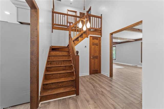 stairs featuring a towering ceiling and hardwood / wood-style flooring