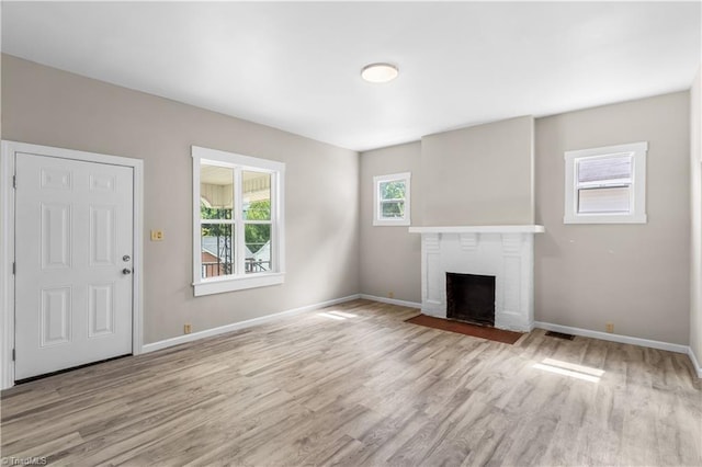 unfurnished living room featuring a fireplace and light wood-type flooring