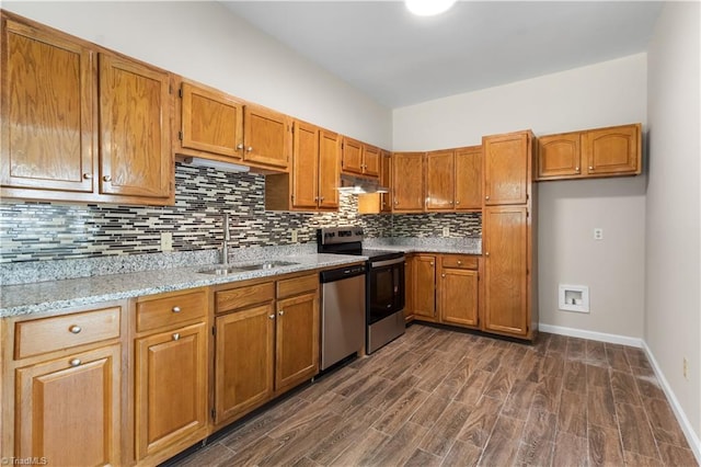 kitchen with light stone counters, sink, backsplash, dark wood-type flooring, and stainless steel appliances