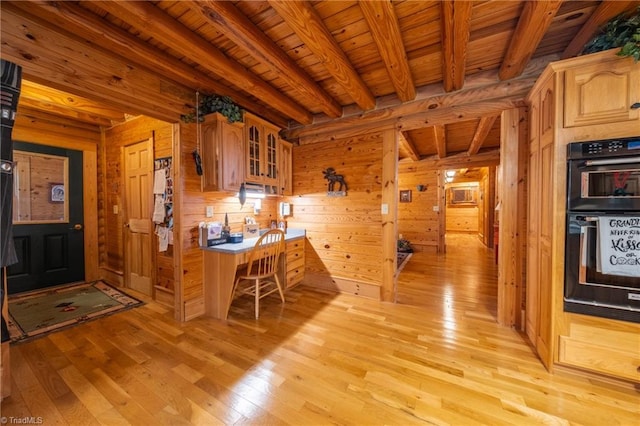 kitchen with beamed ceiling, light hardwood / wood-style floors, wood ceiling, wood walls, and double oven