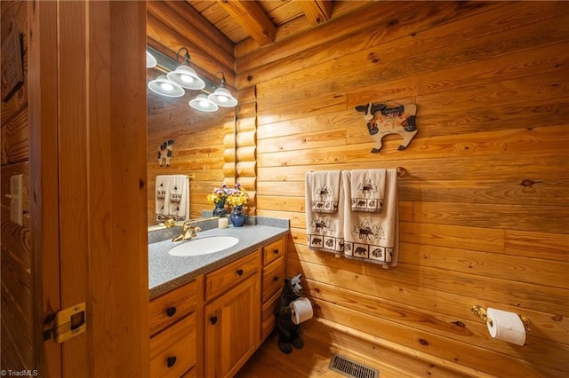 bathroom featuring wood ceiling, vanity, log walls, and beamed ceiling