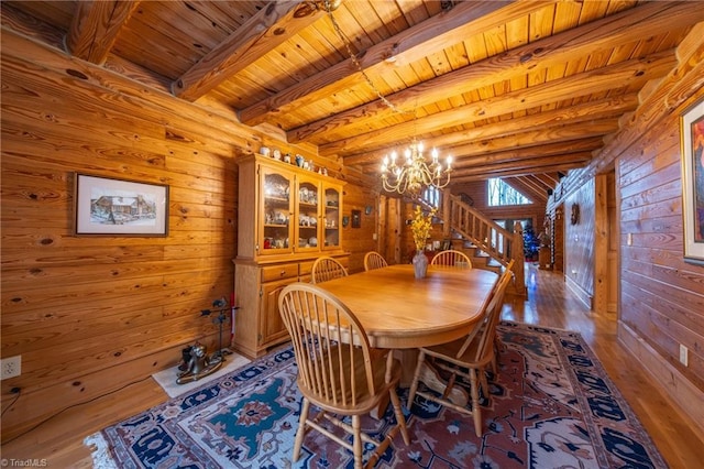 dining space featuring wood ceiling, beamed ceiling, an inviting chandelier, and light hardwood / wood-style floors