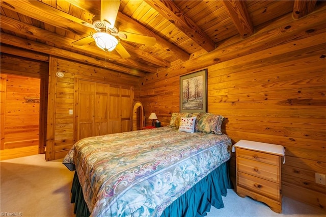 carpeted bedroom featuring ceiling fan, beam ceiling, and wood ceiling