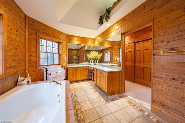 bathroom with wood walls, a bathtub, and vanity