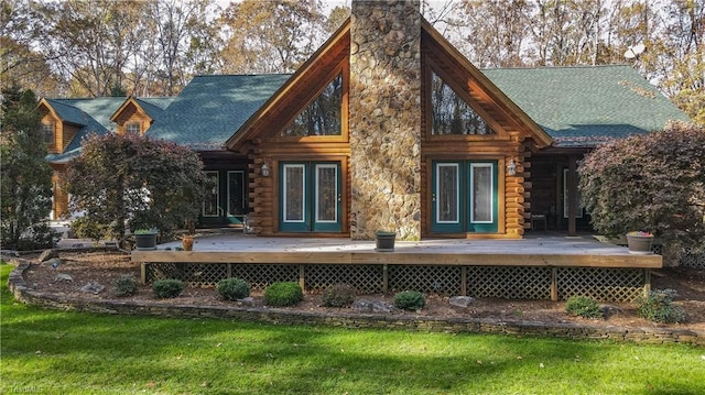 rear view of house with a lawn and a wooden deck