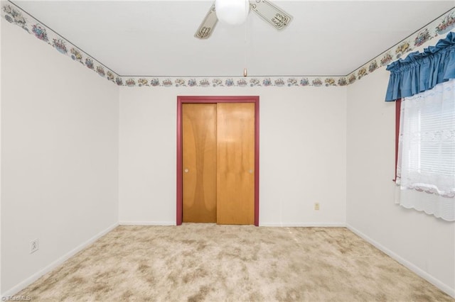 carpeted spare room with ceiling fan