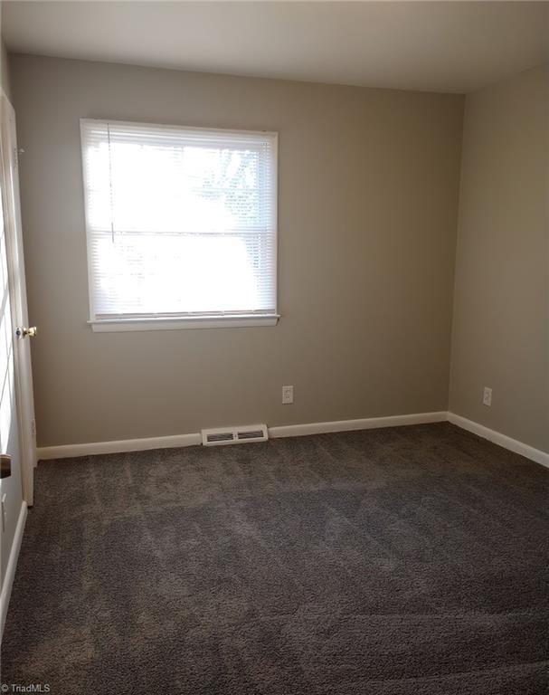 empty room featuring dark colored carpet