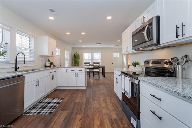 kitchen with visible vents, a sink, white cabinetry, appliances with stainless steel finishes, and dark wood-style flooring