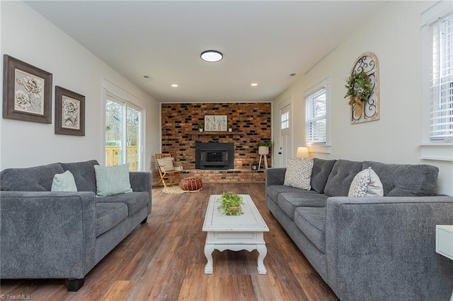 living room featuring visible vents, a healthy amount of sunlight, and dark wood-style floors