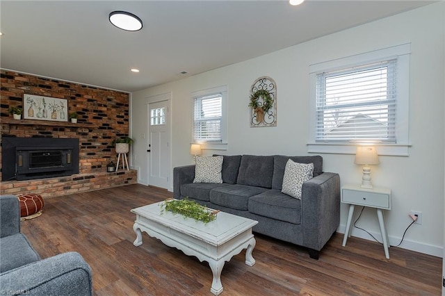 living room featuring recessed lighting, a brick fireplace, baseboards, and wood finished floors