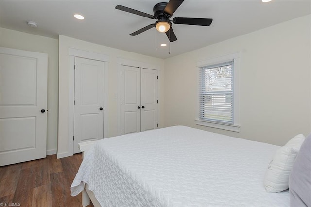 bedroom featuring a ceiling fan, recessed lighting, dark wood-style floors, and two closets