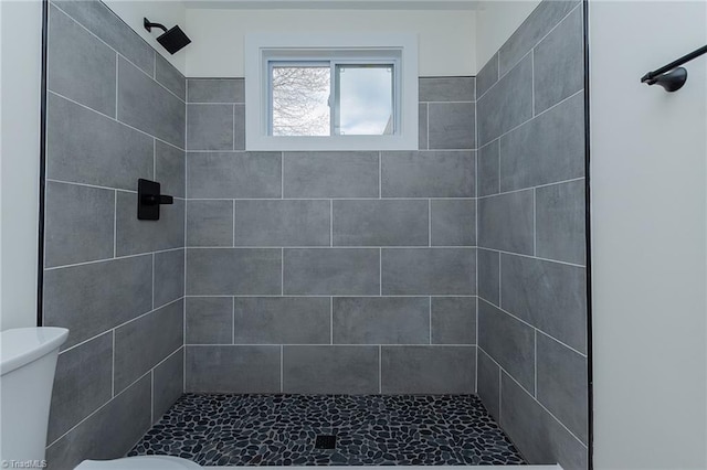 full bathroom with tiled shower and toilet