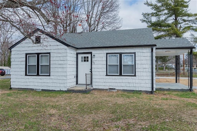 view of front of property featuring a chimney, roof with shingles, and a front yard