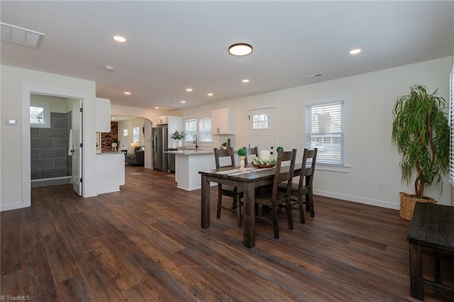 dining area with recessed lighting, visible vents, arched walkways, and dark wood-style floors