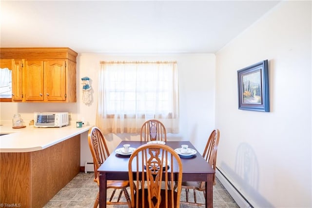 dining space featuring a toaster, baseboard heating, and light tile patterned flooring