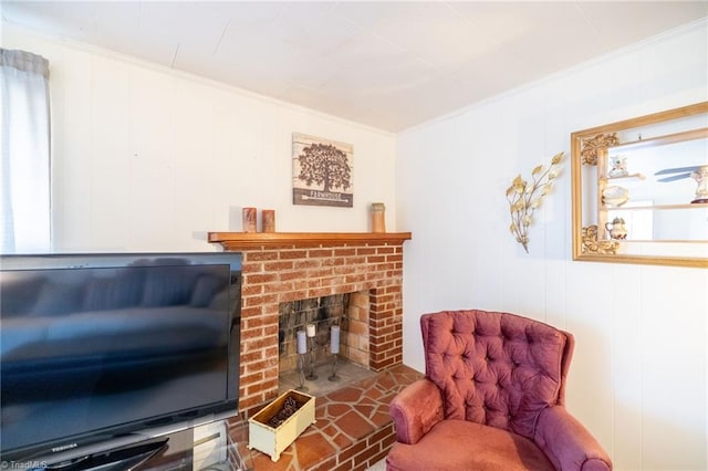 sitting room featuring ornamental molding and a brick fireplace