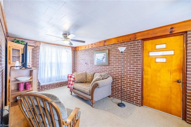 living room with a ceiling fan, light carpet, and brick wall