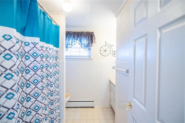 bathroom with tile walls, a baseboard radiator, toilet, wainscoting, and tile patterned floors