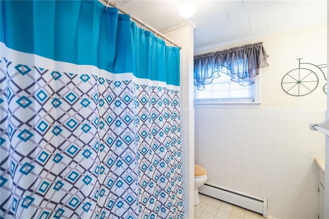 bathroom with toilet, a wainscoted wall, a baseboard radiator, tile patterned floors, and tile walls